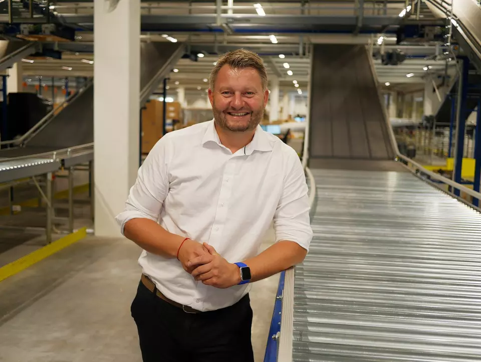 Logistikksjef Bjørn Tore Svendsen i Komplett-gruppen i første etasje i nybygget, ved sorteringsanlegget som brukes til den utgående varestrømmen. Foto: Stian Sønsteng