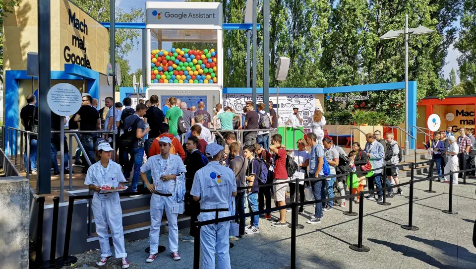 Hvitkledte Google-assistenter svarer på spørsmål fra publikum og deler ut frukt. Foto: Marte Ottemo. Hvitkledte Google-assistenter svarer på spørsmål fra publikum og deler ut frukt. Foto: Marte Ottemo.