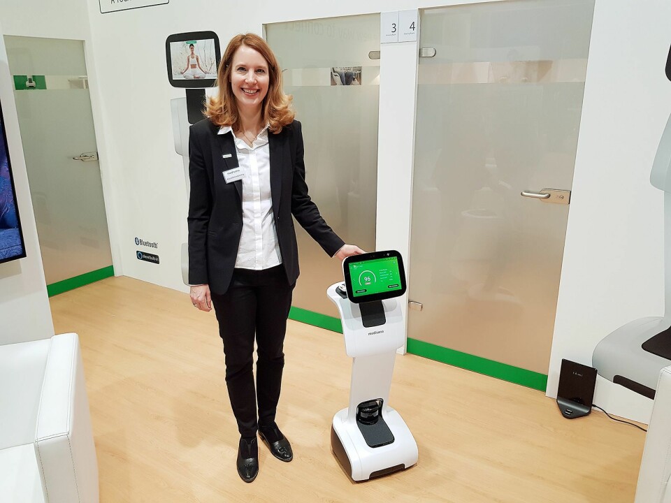 Anja Schimmelpfenning fra Medisana viser frem Homecare Robot. Legg merke til basestasjonen nede i høyre hjørne. Foto: Jan Røsholm.