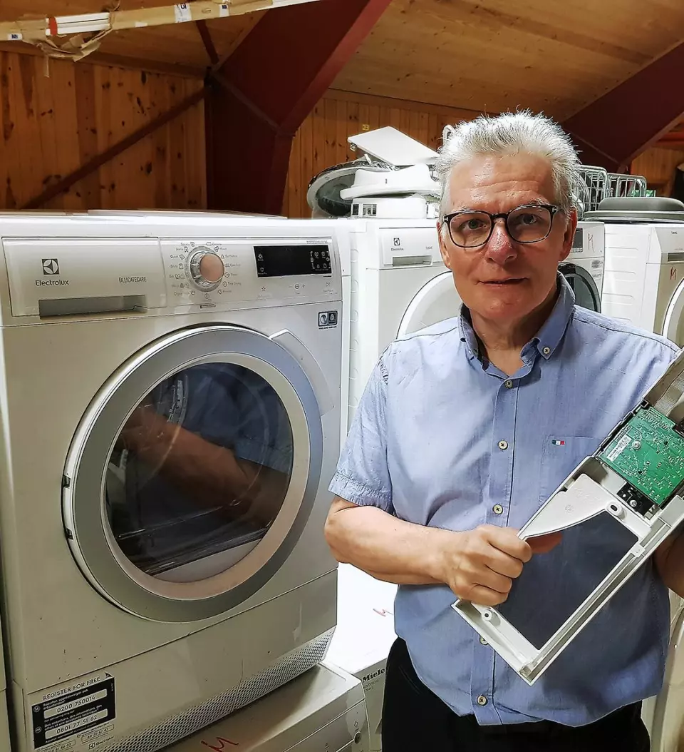 Tommy Paulsen med et styringskort til en vaskemaskin, en modul de ofte bytter. Foto: Jan Røsholm