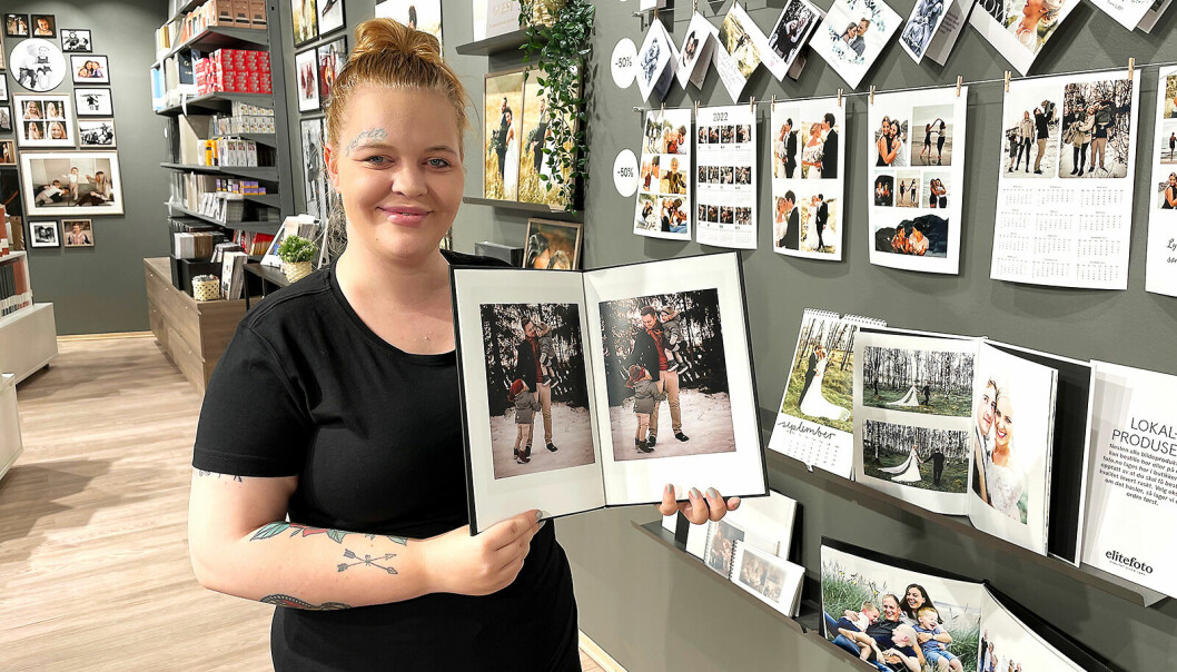 Butikkmedarbeider Sofie Kvåvik ved Elite Foto Gulskogen med kjedens ekspress fotobok. Foto: Stian Sønsteng