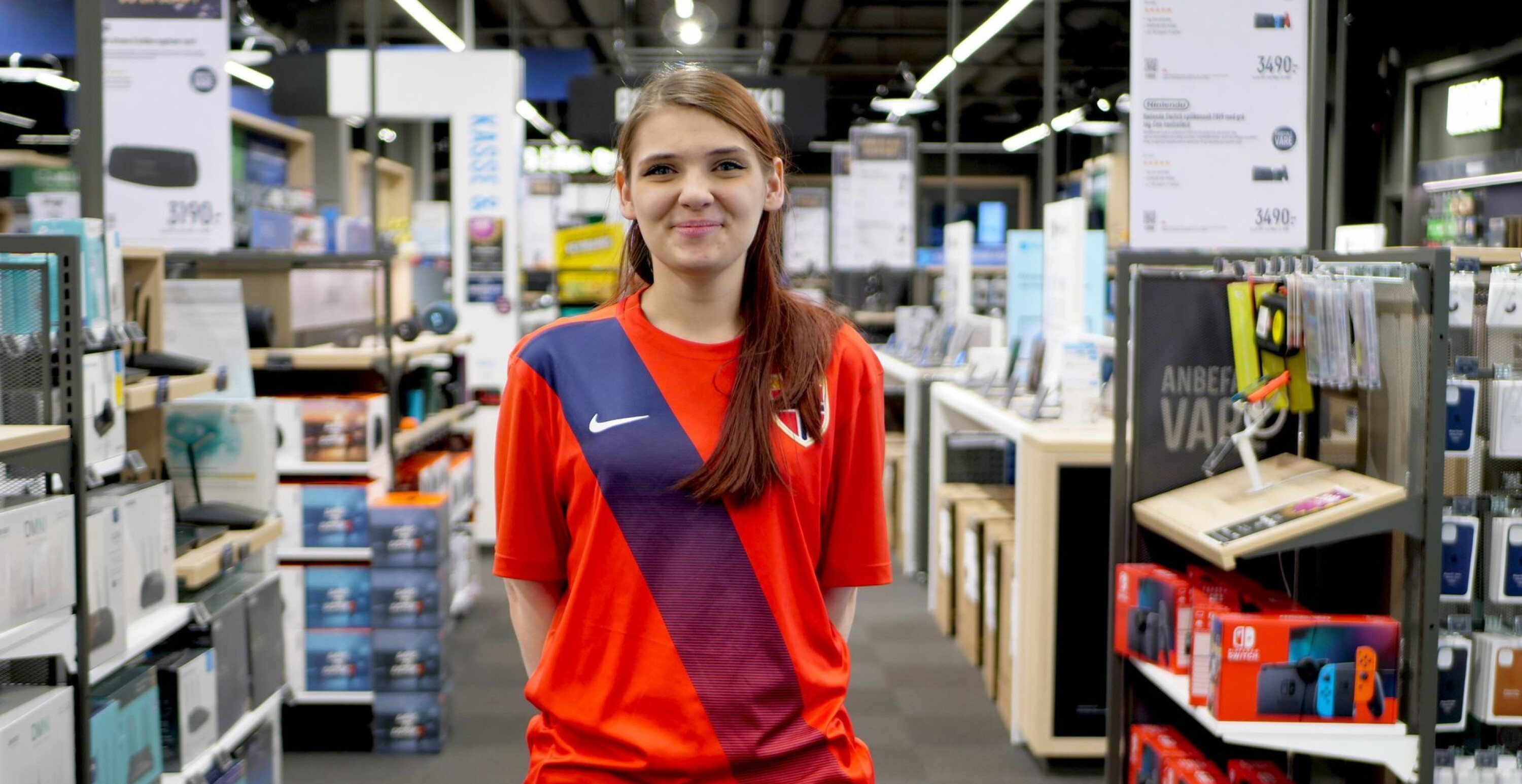 Fredag aksjonerer Elkjøp og en rekke andre bedrifter til inntekt for Barnekreftforeningen gjennom #Fotballtrøyefredag. Her Isabell Karlsen ved Elkjøp Gulskogen. Foto: Elkjøp Norge