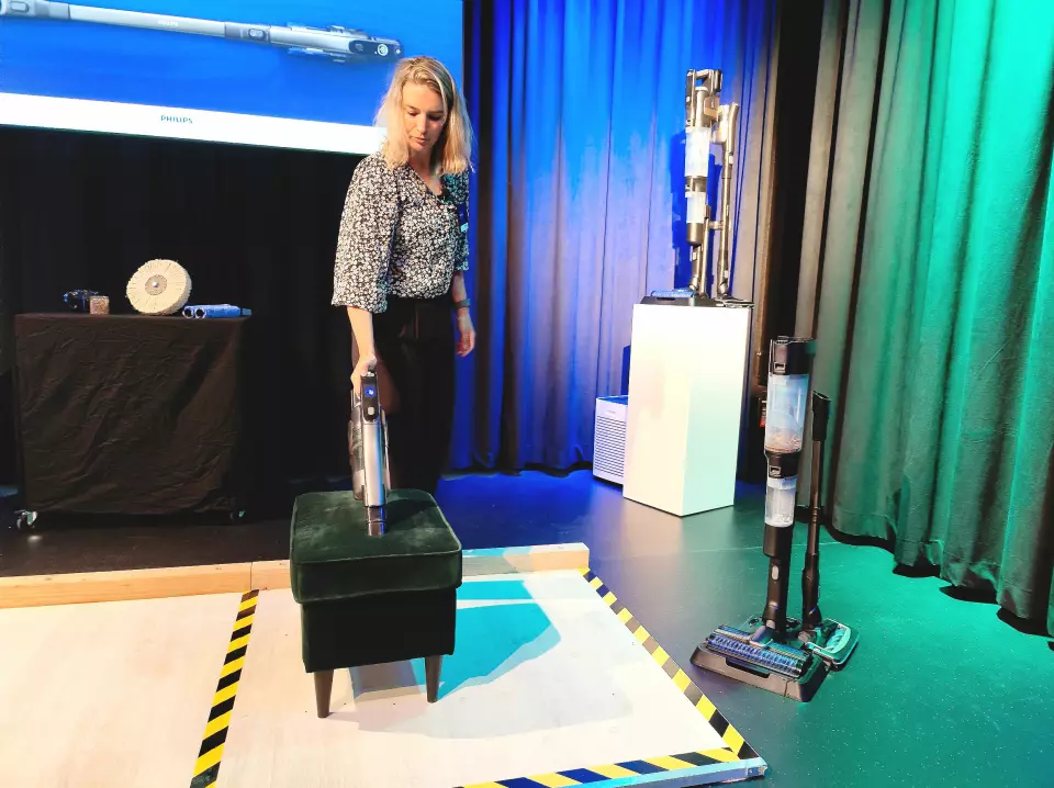 Lotte Medema viser hvordan AquaTrio 9000 kan brukes som håndholdt støvsuger. Foto: Stian Sønsteng